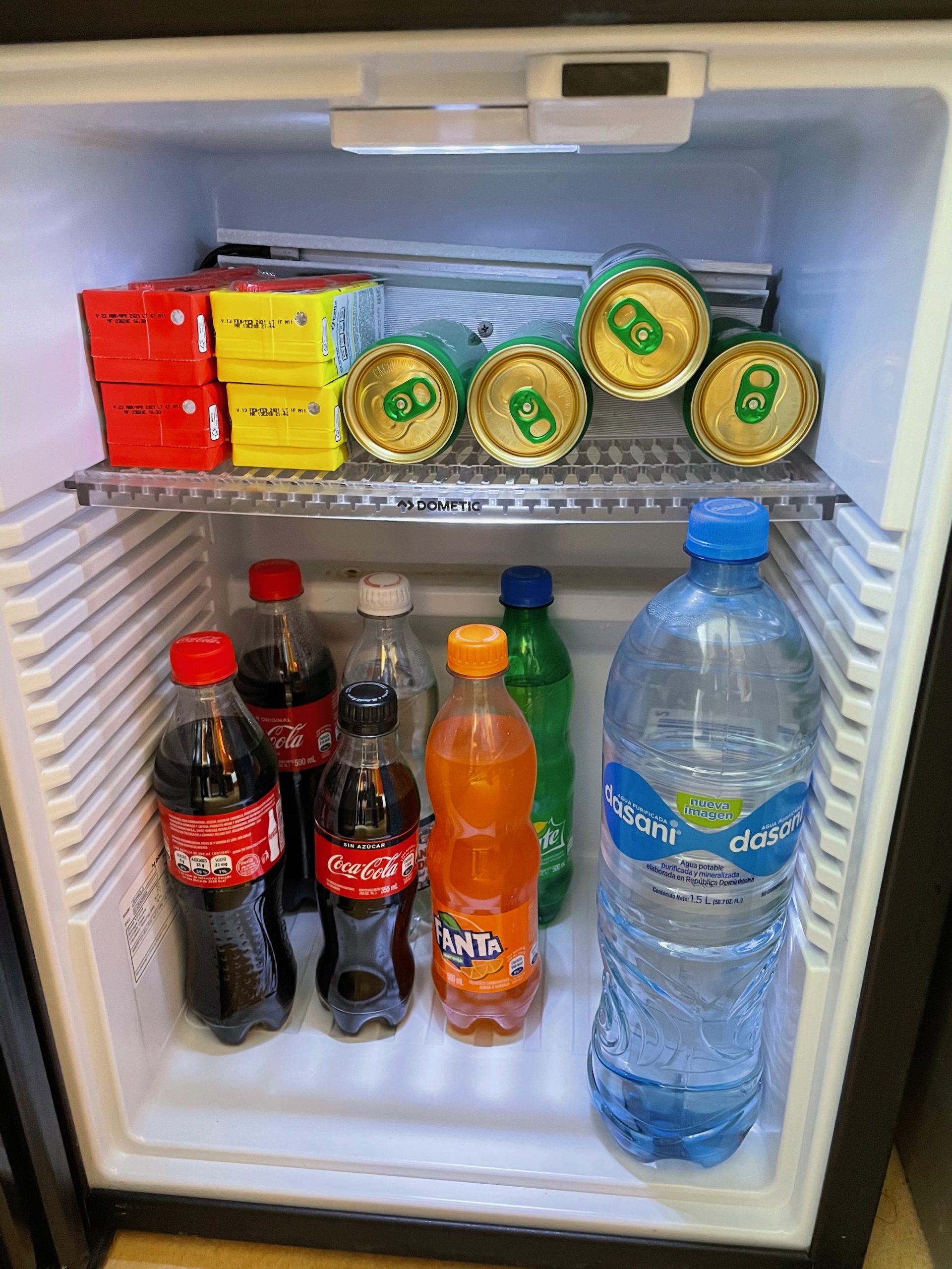 a refrigerator with bottles and cans of soda