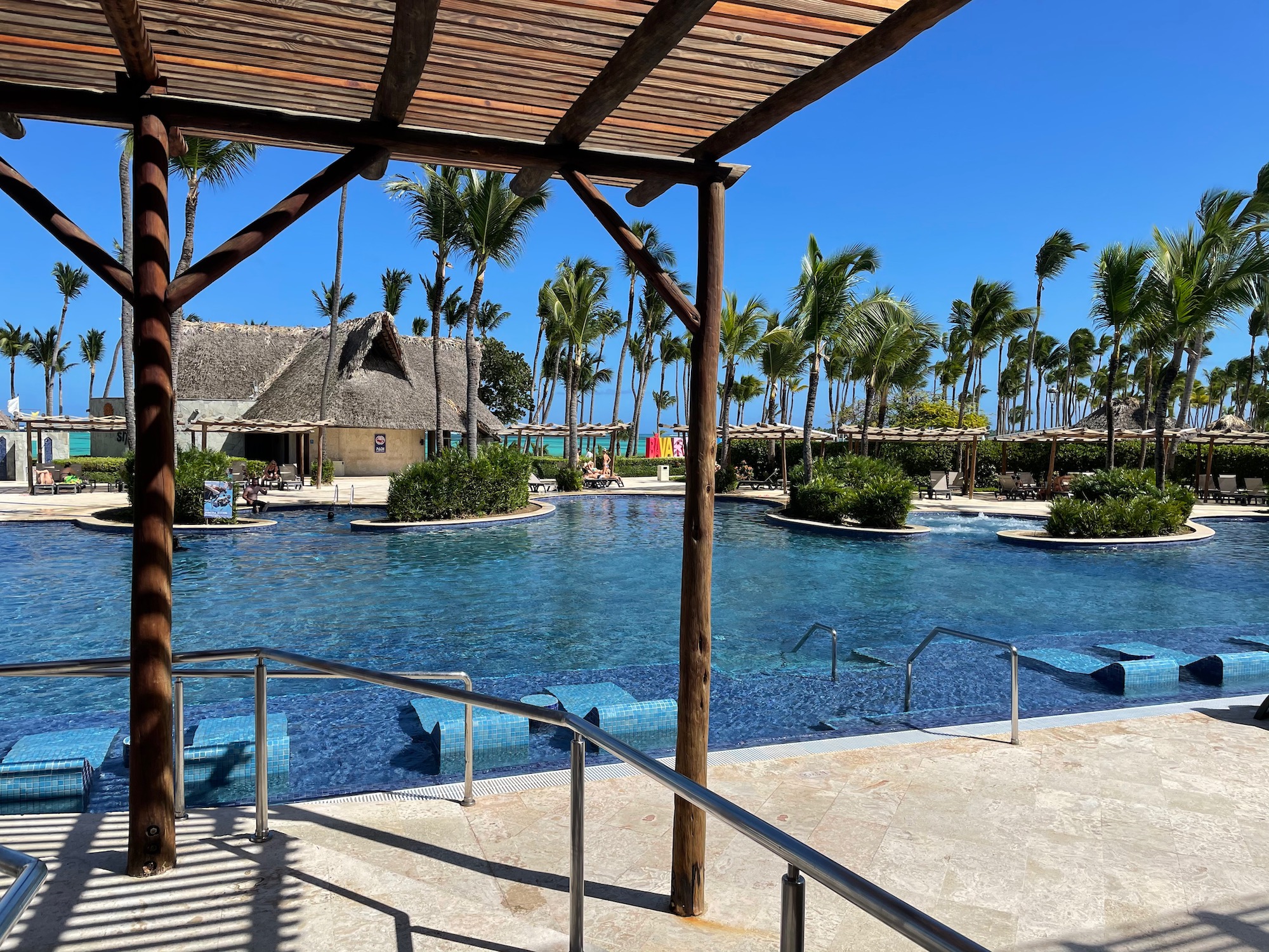 a pool with a gazebo and palm trees