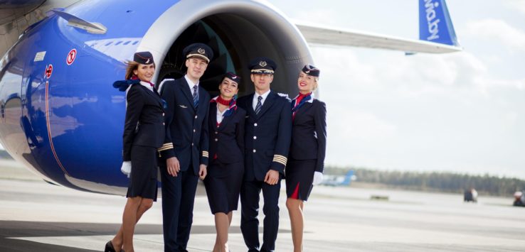 a group of people in uniform standing in front of an airplane