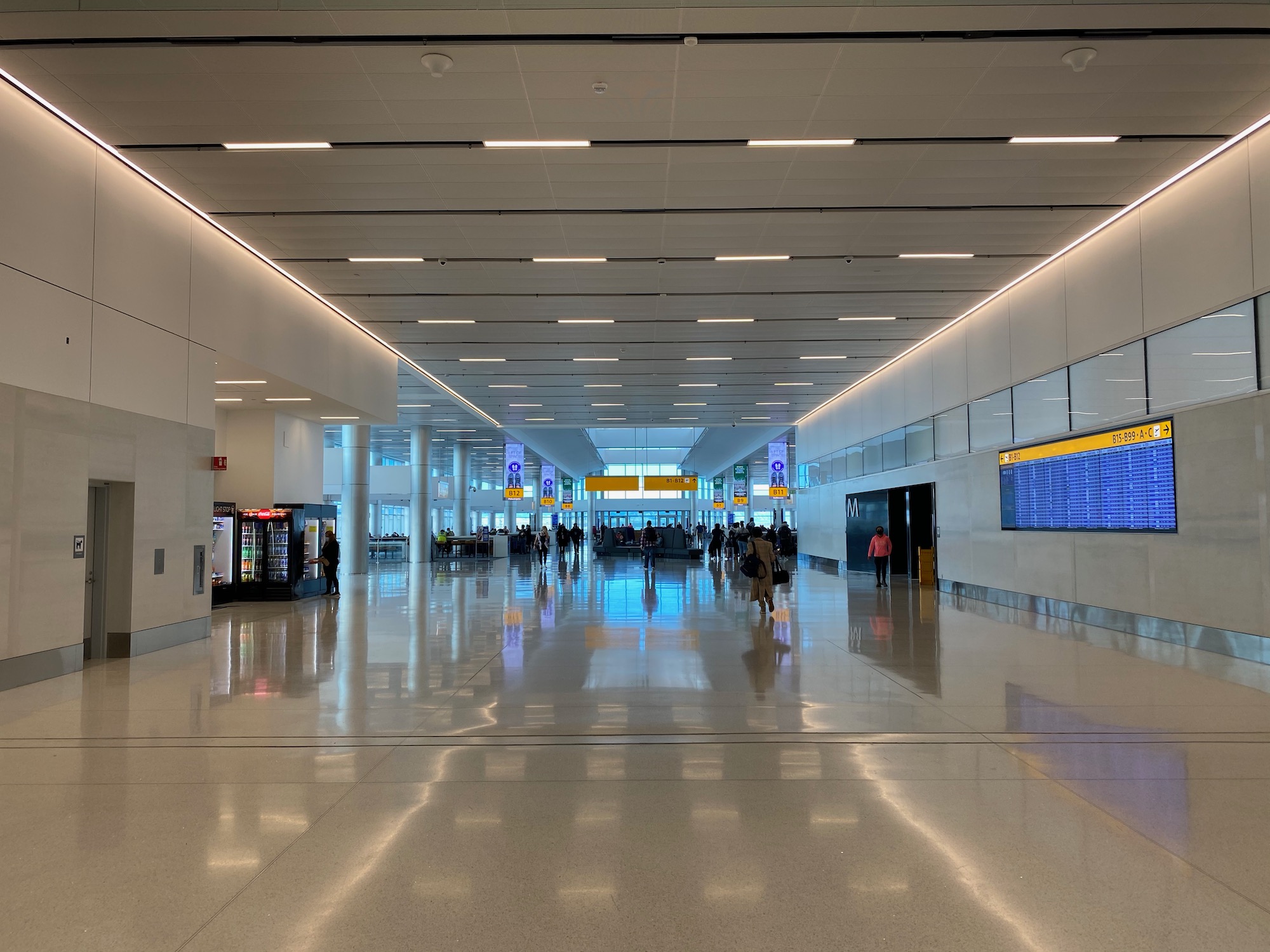 a large white hall with people walking in it