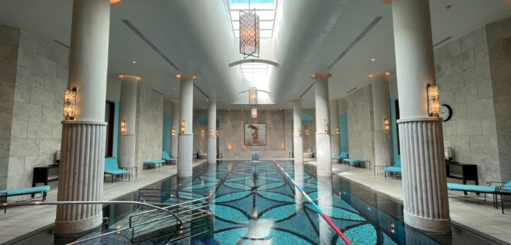a indoor pool with blue water and blue chairs