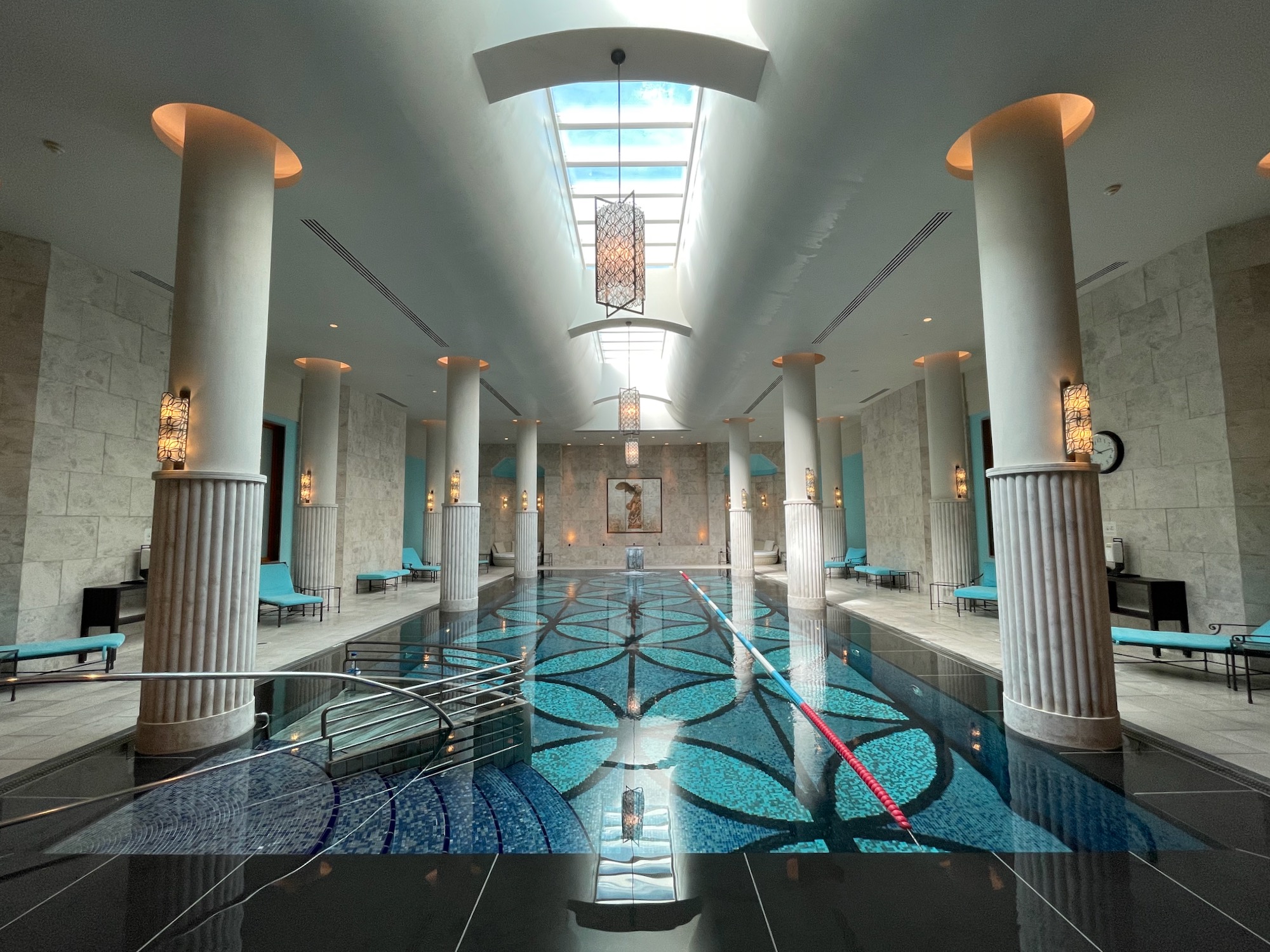 a indoor pool with blue water and blue chairs