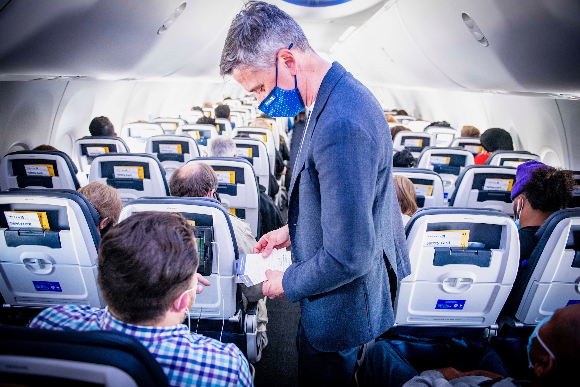 a man wearing a mask and standing in an airplane