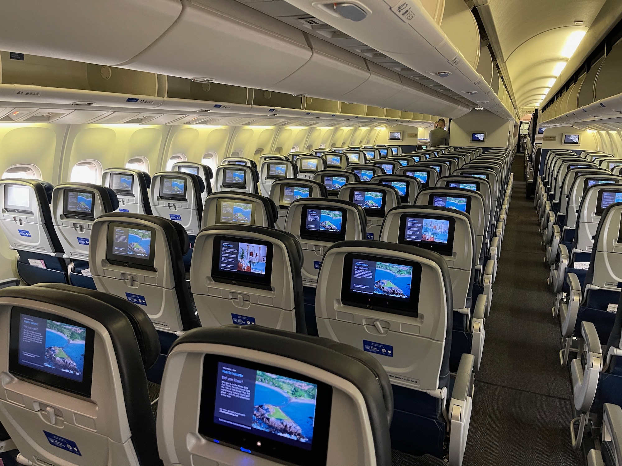 an airplane with rows of seats and monitors