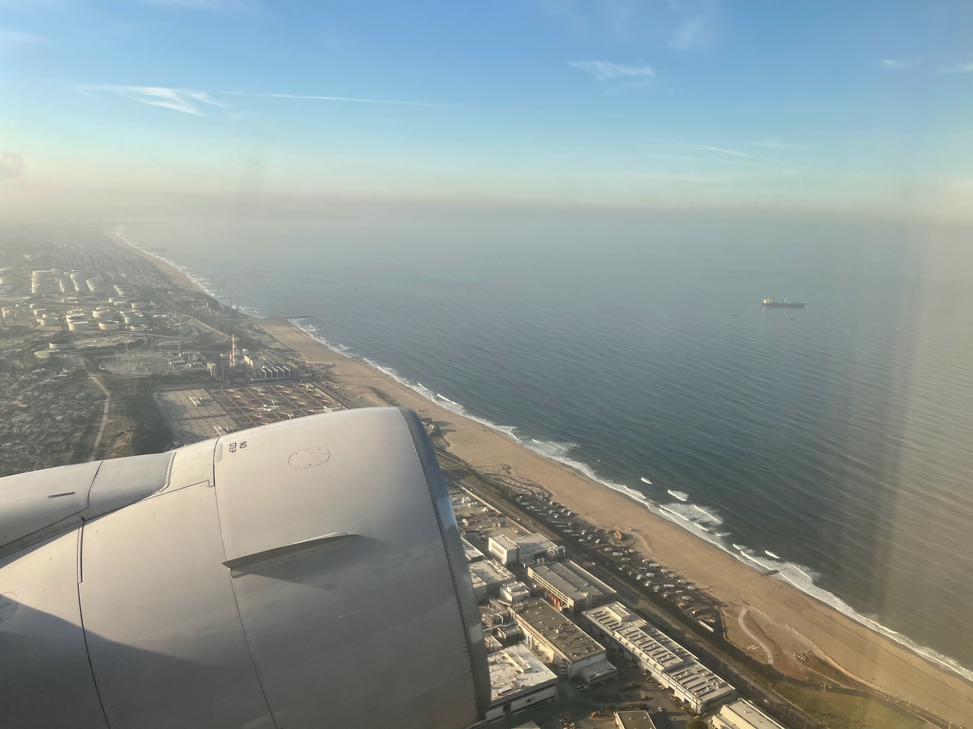 an airplane wing and engine of an airplane near a beach