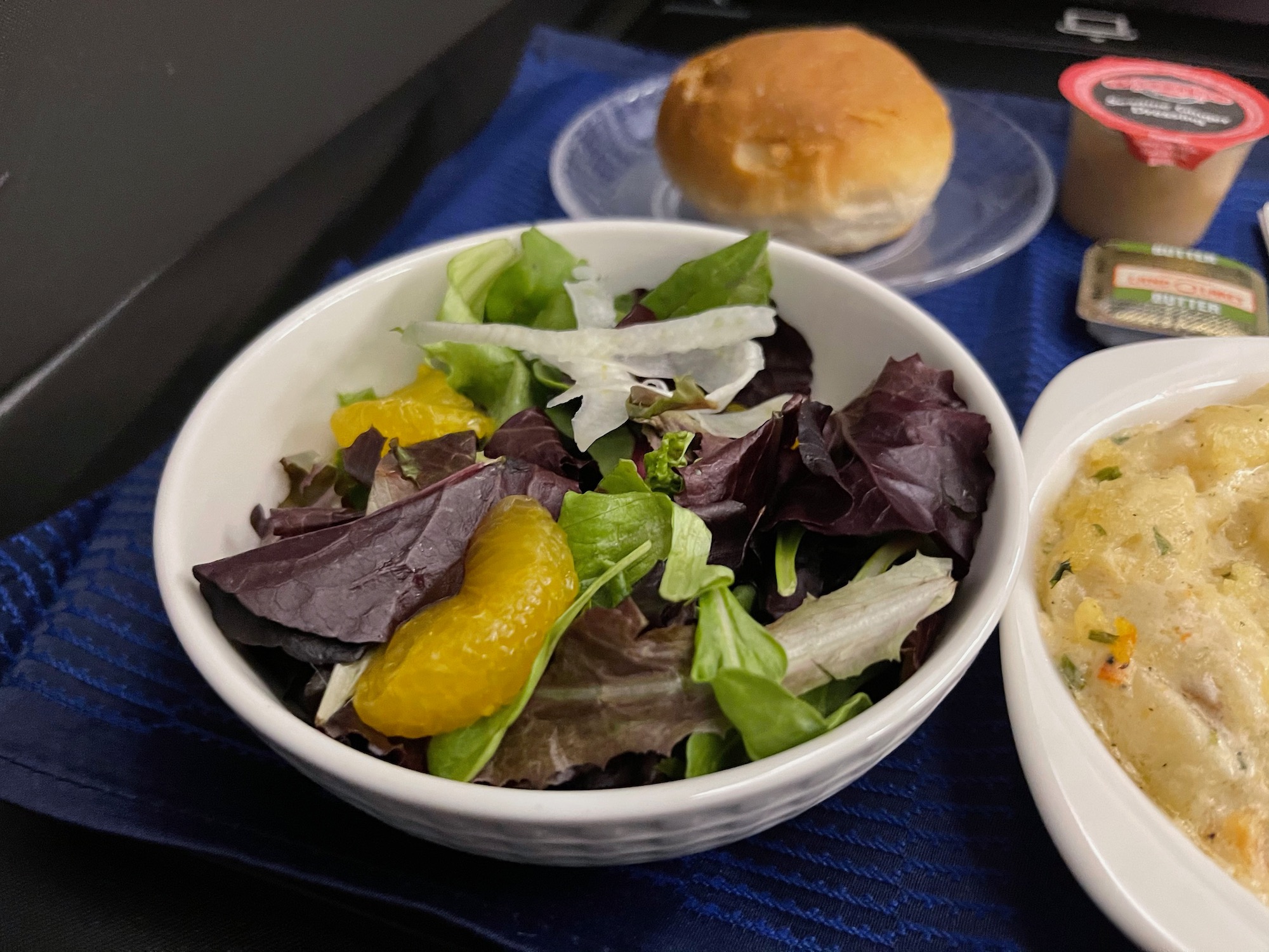 a bowl of salad and a bun