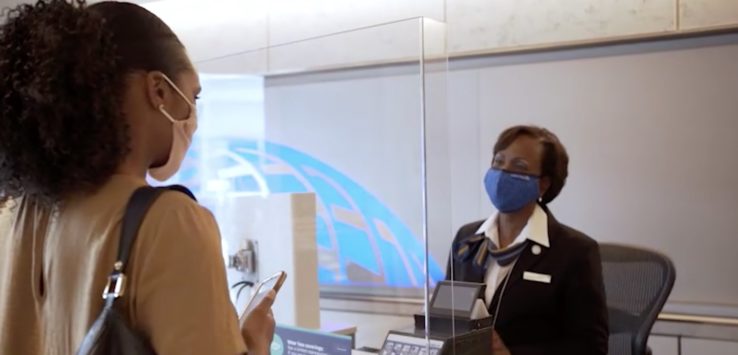 a woman wearing face masks and standing next to a glass case