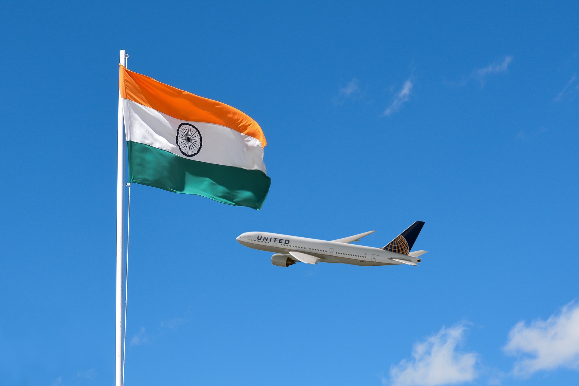 an airplane flying in the sky next to a flag