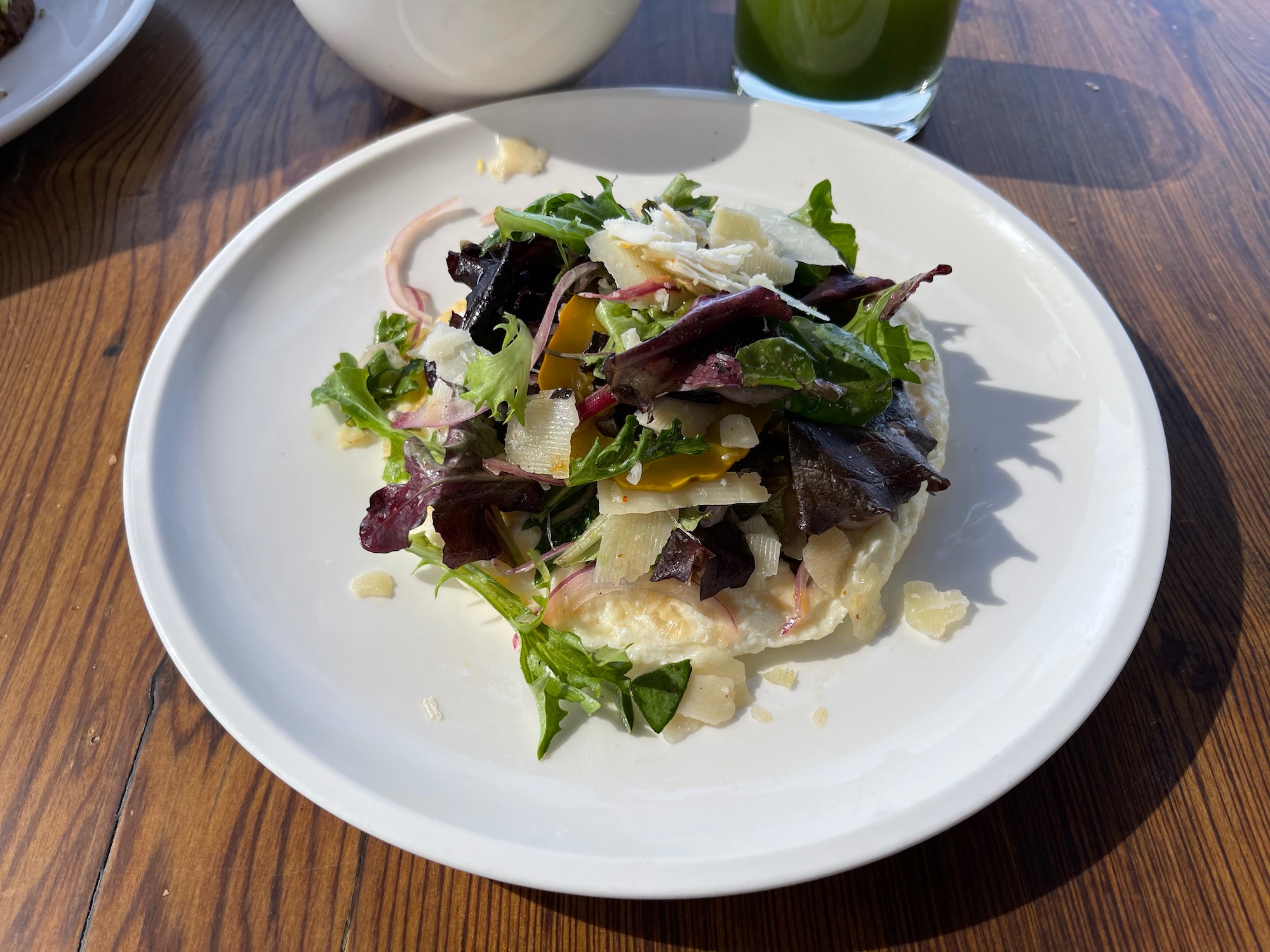 a plate of salad with a glass of juice