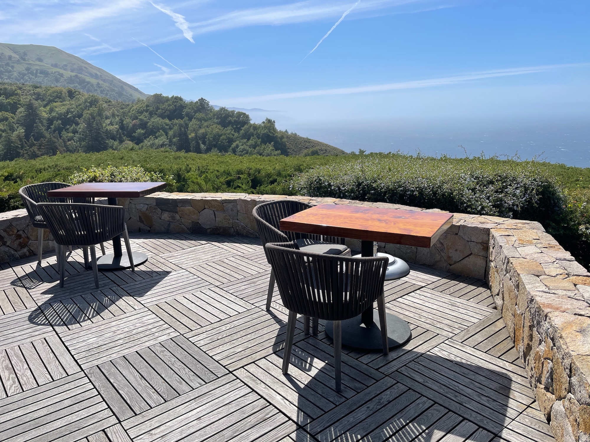 a table and chairs on a patio overlooking a vineyard
