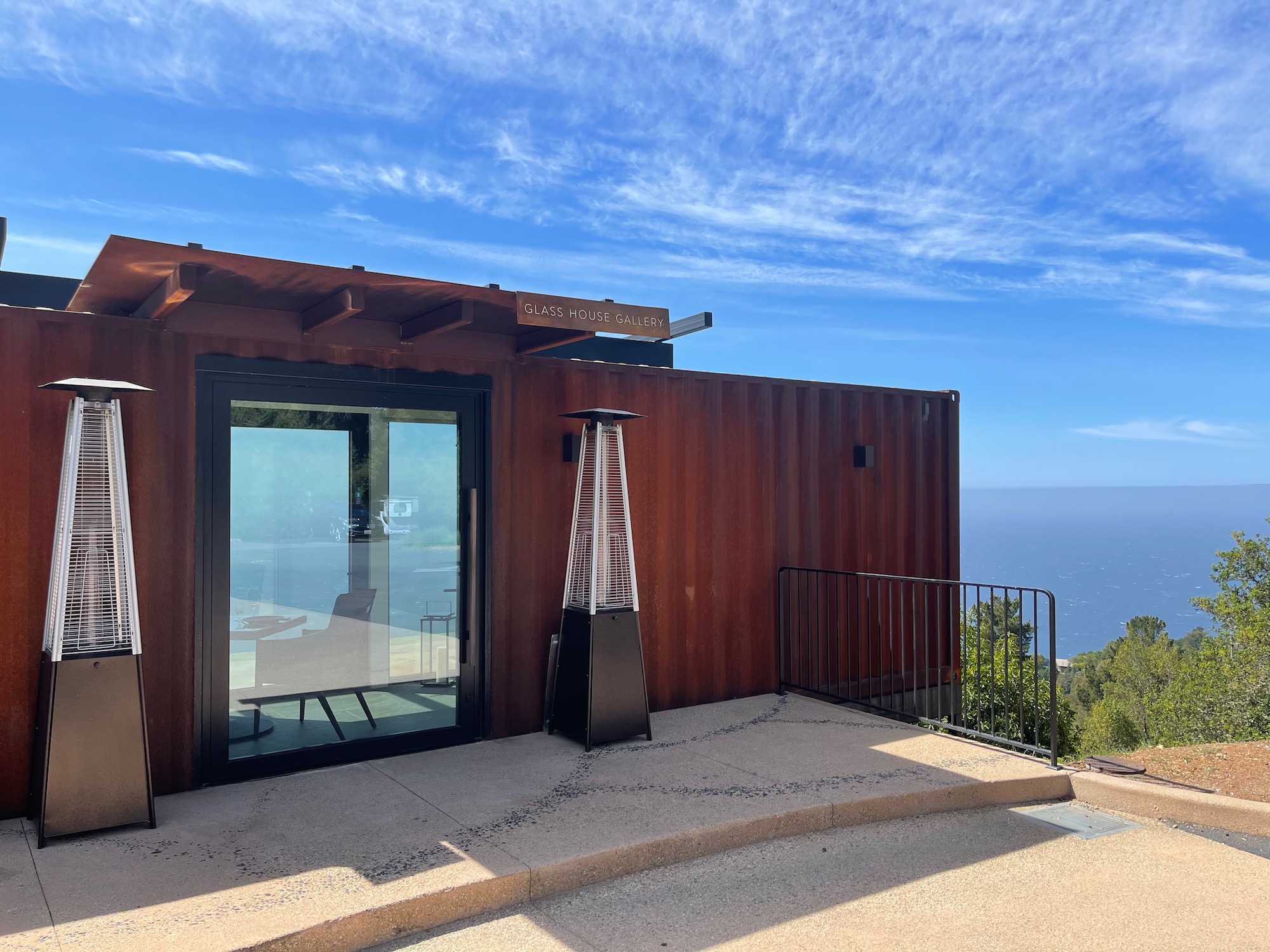 a building with a glass door and a balcony overlooking the ocean