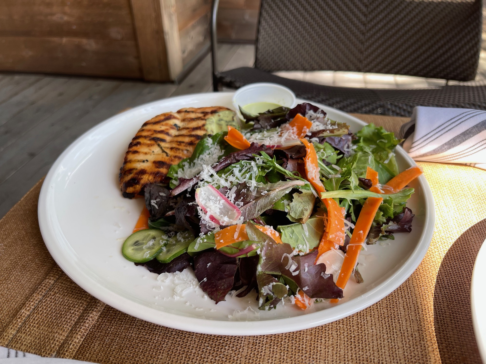 a plate of salad with grilled chicken and vegetables