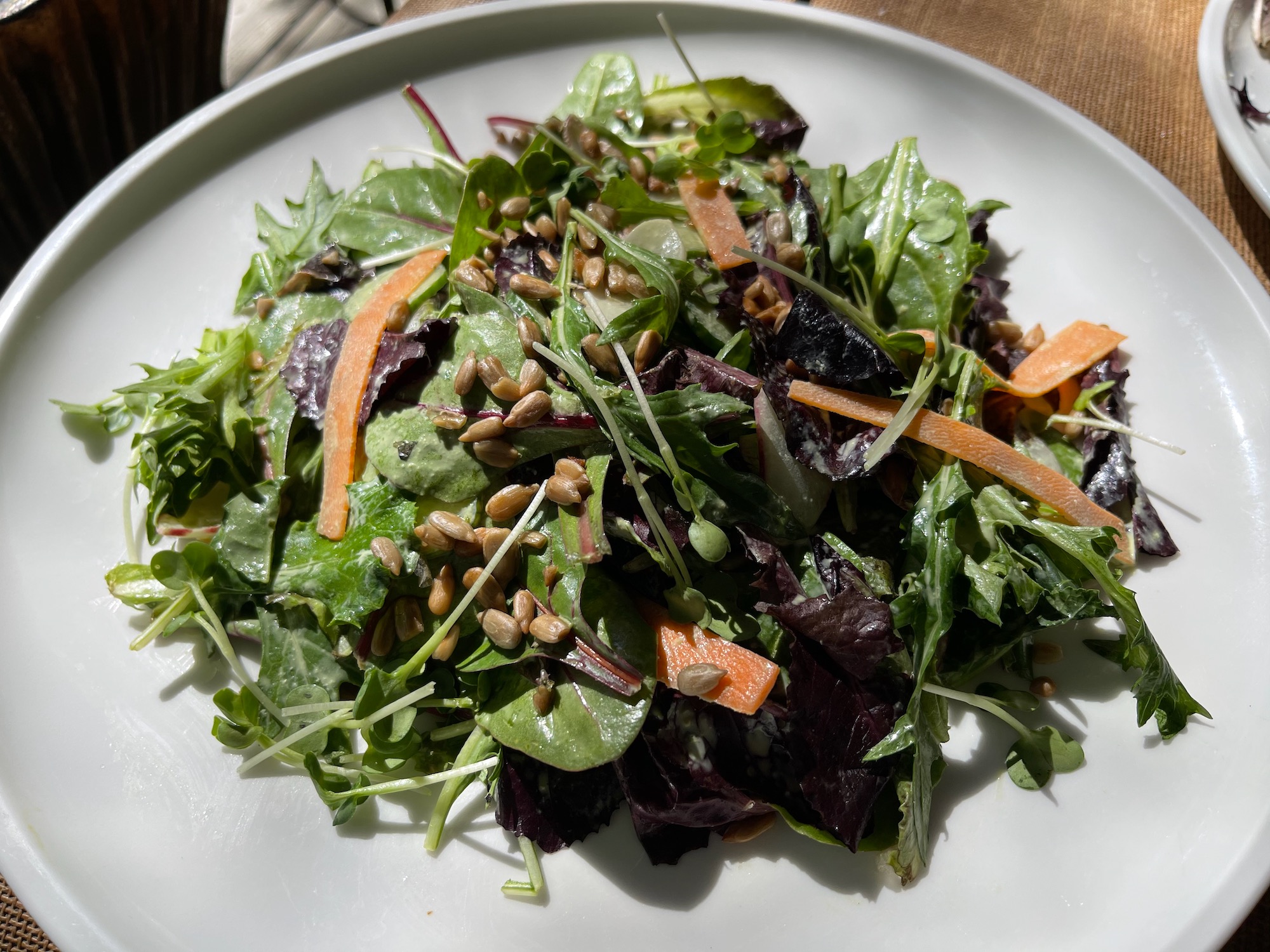 a plate of salad with greens and carrots