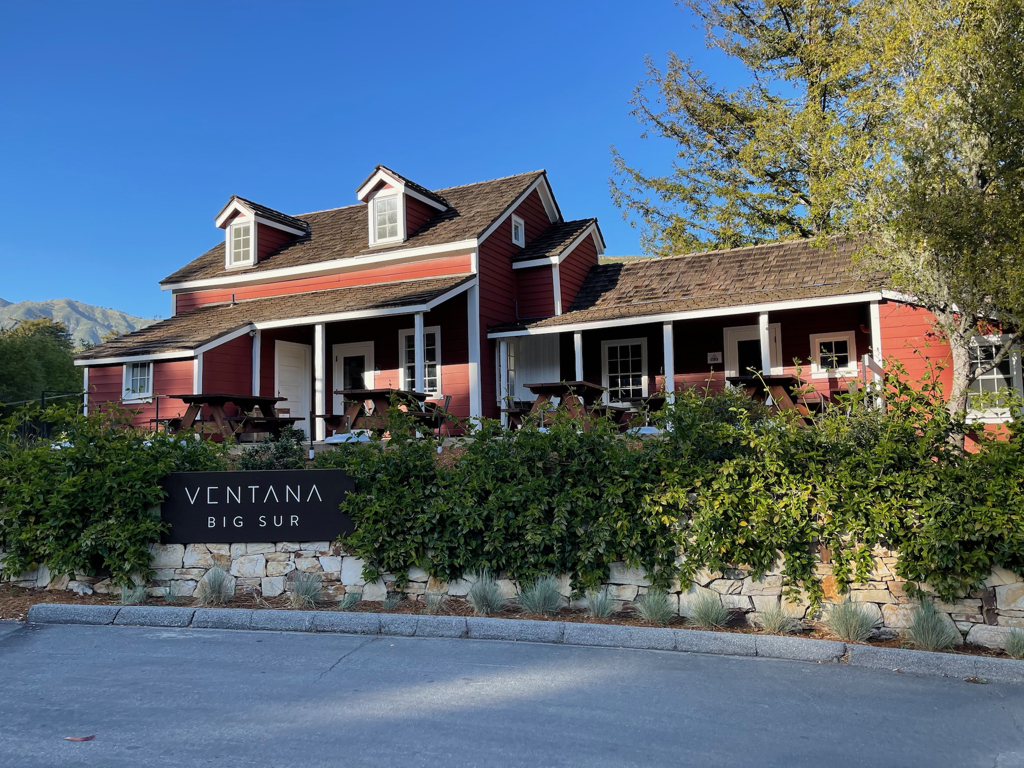 a red house with white trim and a sign