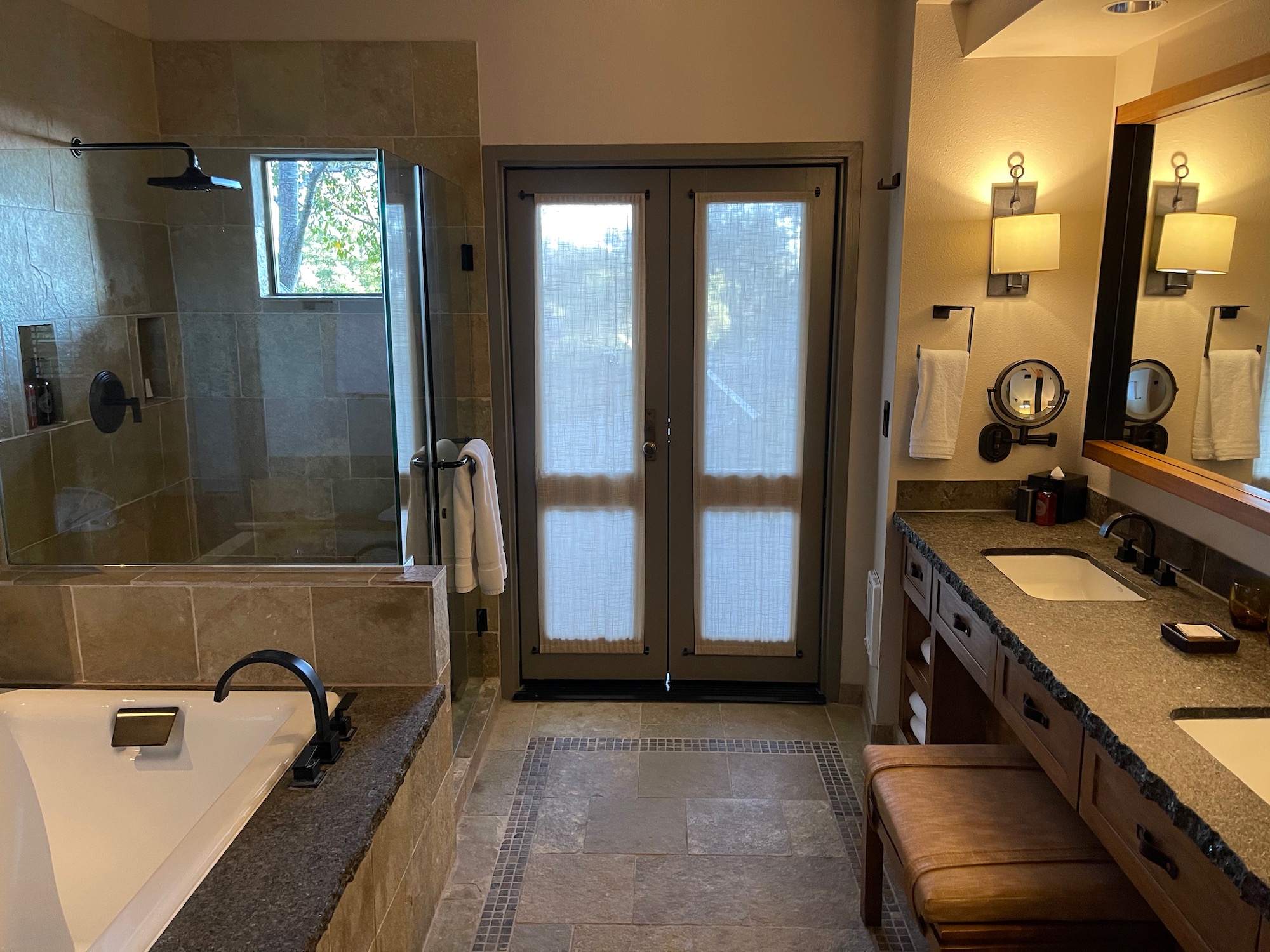 a bathroom with double doors and a bathtub