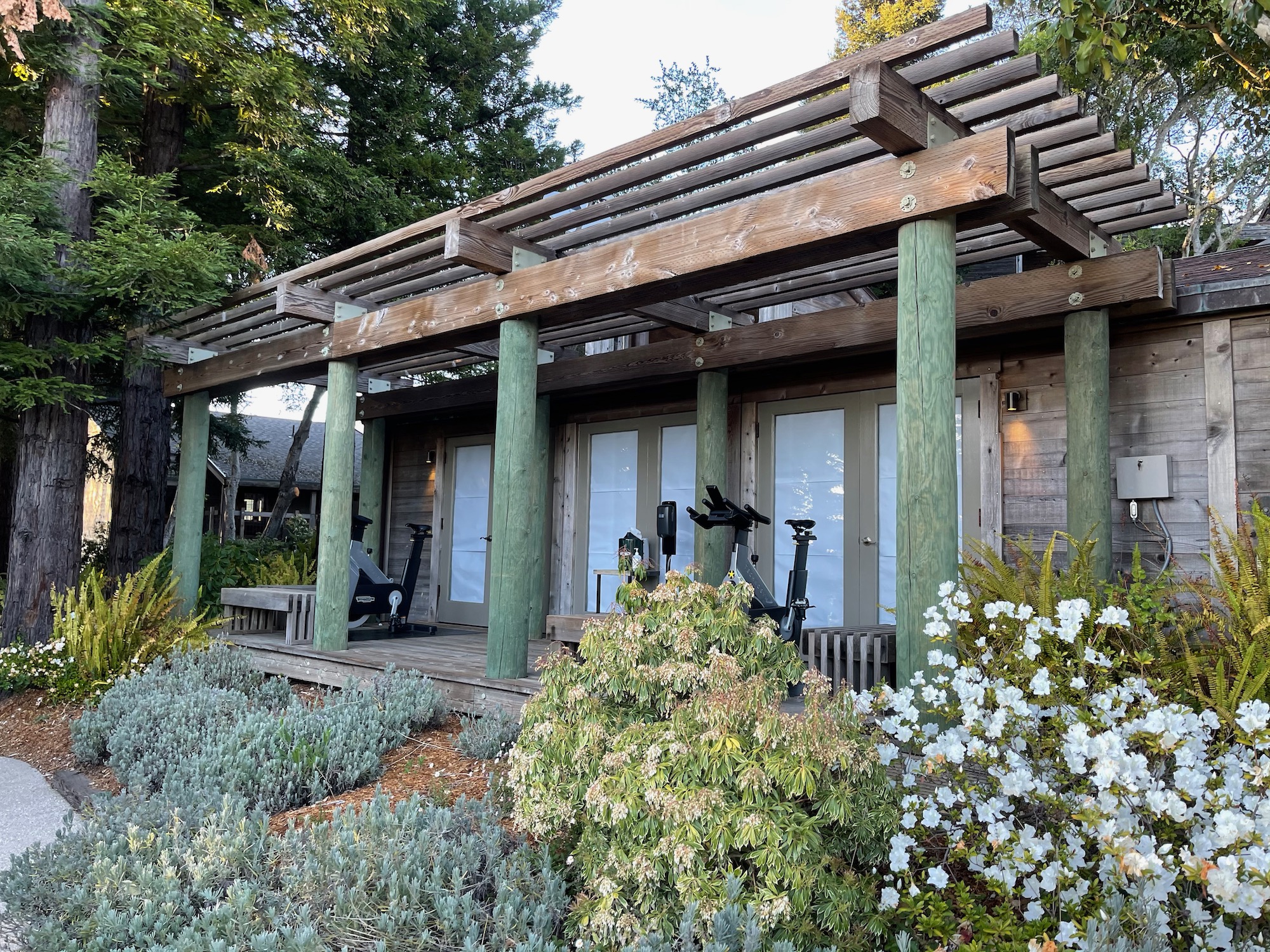 a building with a pergola and exercise bikes