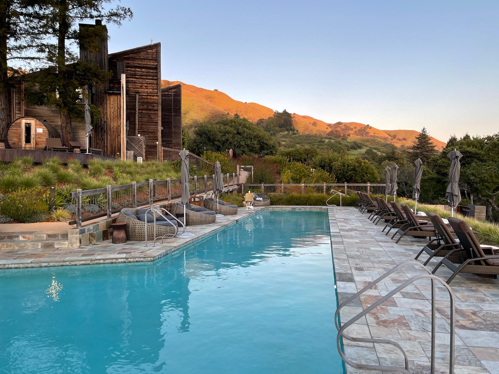 a pool with chairs and a building in the background