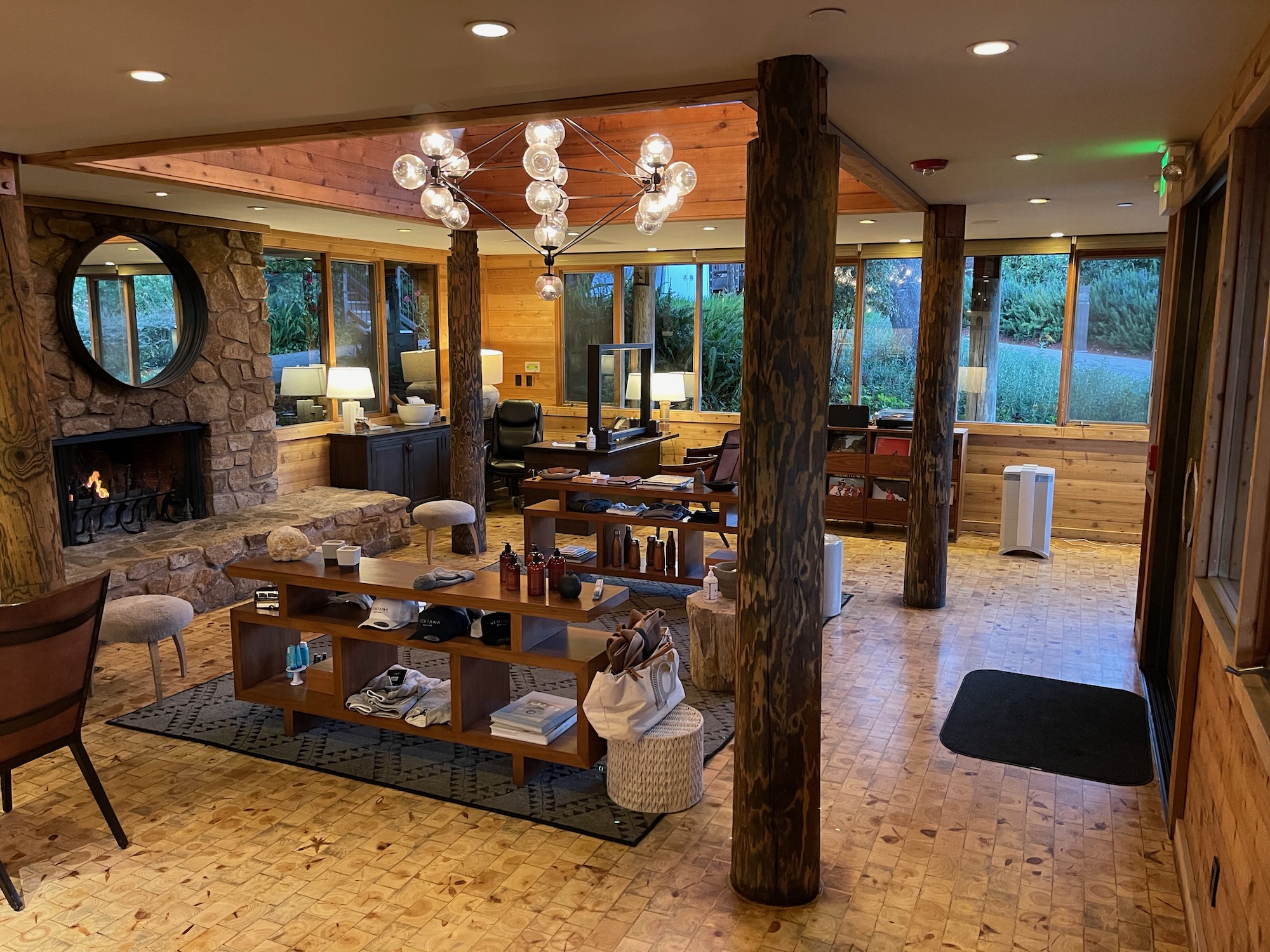 a room with a wood floor and a stone fireplace