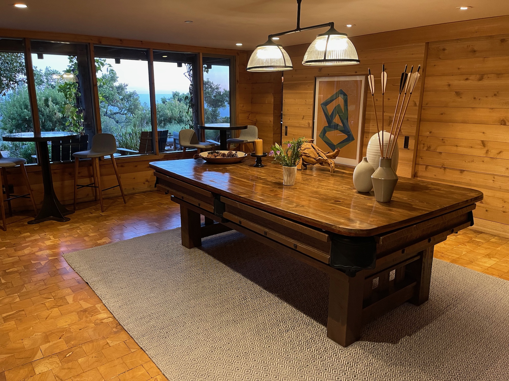 a pool table in a room with windows and a view of the ocean