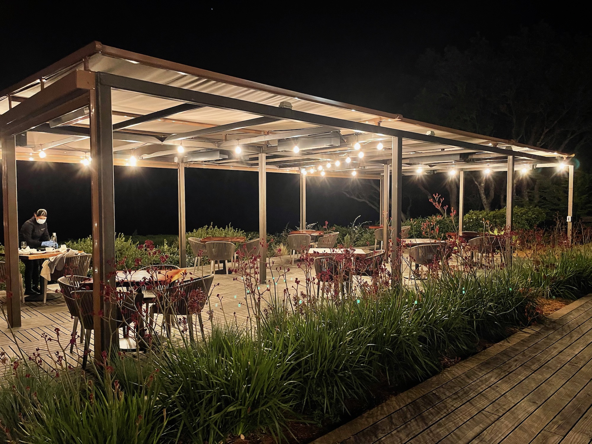 a covered patio with tables and chairs at night