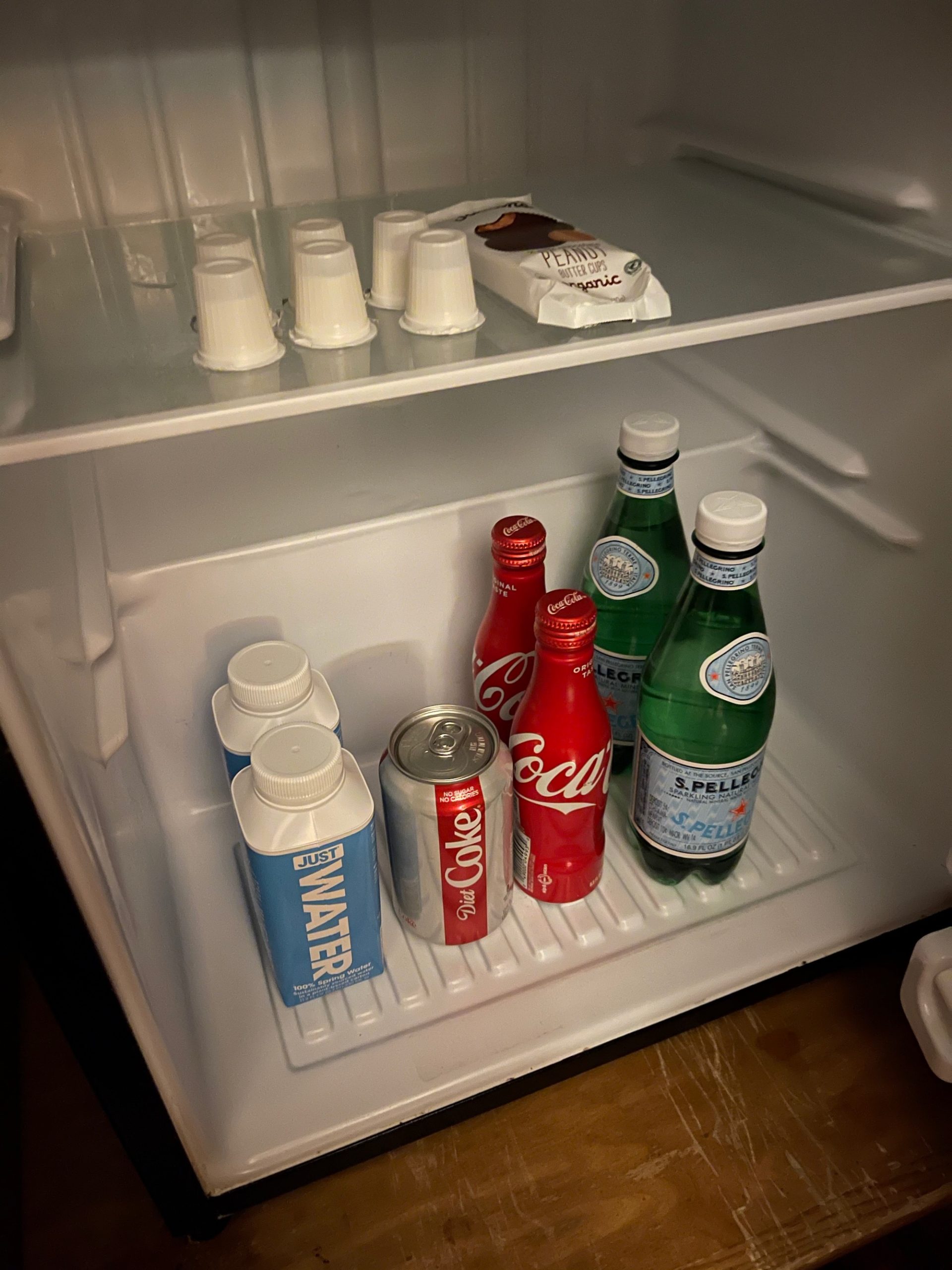 a refrigerator with bottles and cups