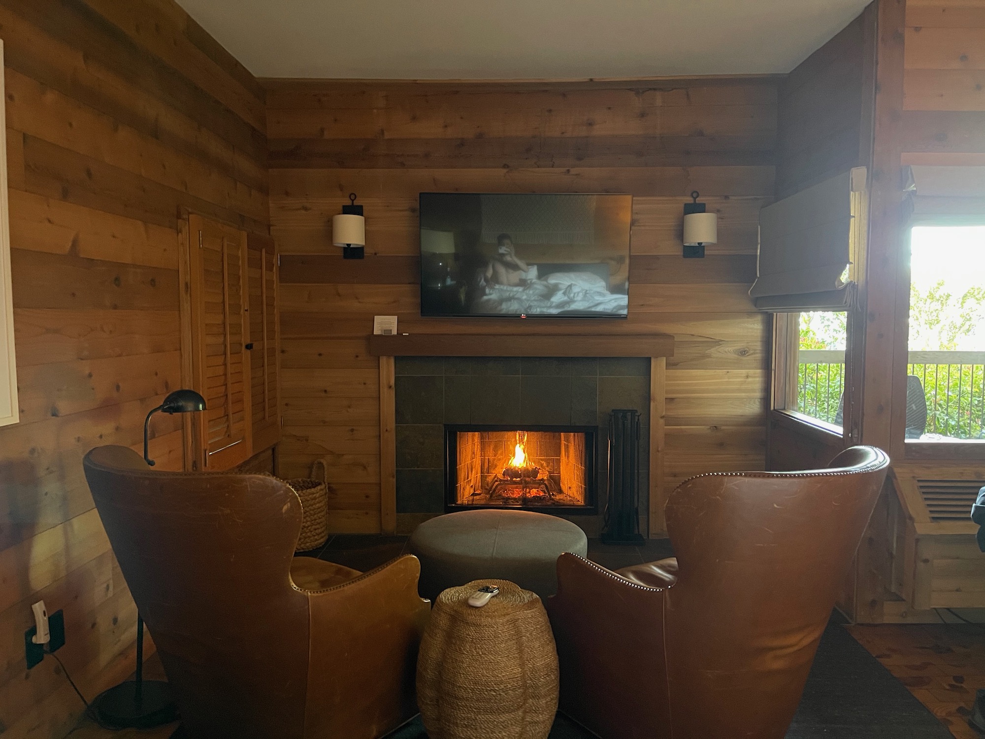 a fireplace in a room with leather chairs and a television
