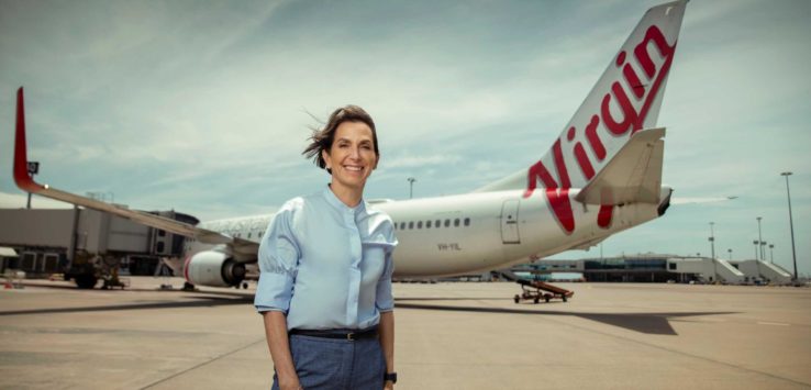 a woman standing in front of an airplane