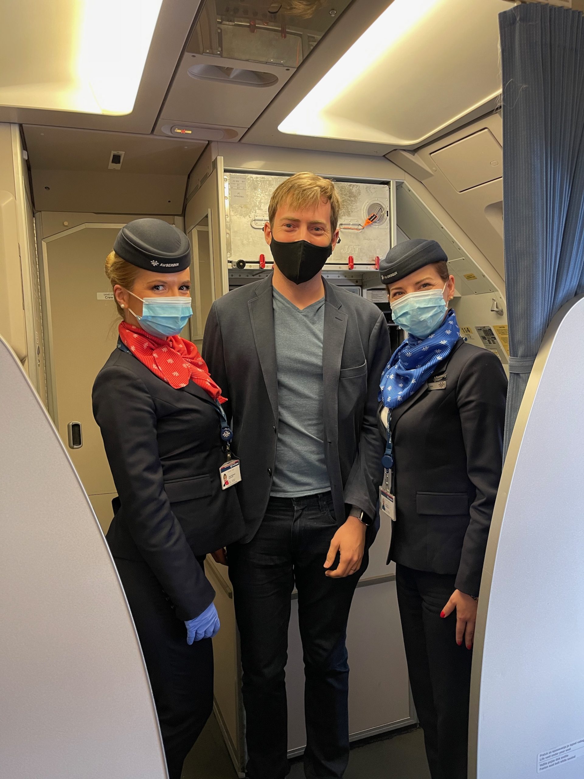 a group of people wearing masks and standing in a plane