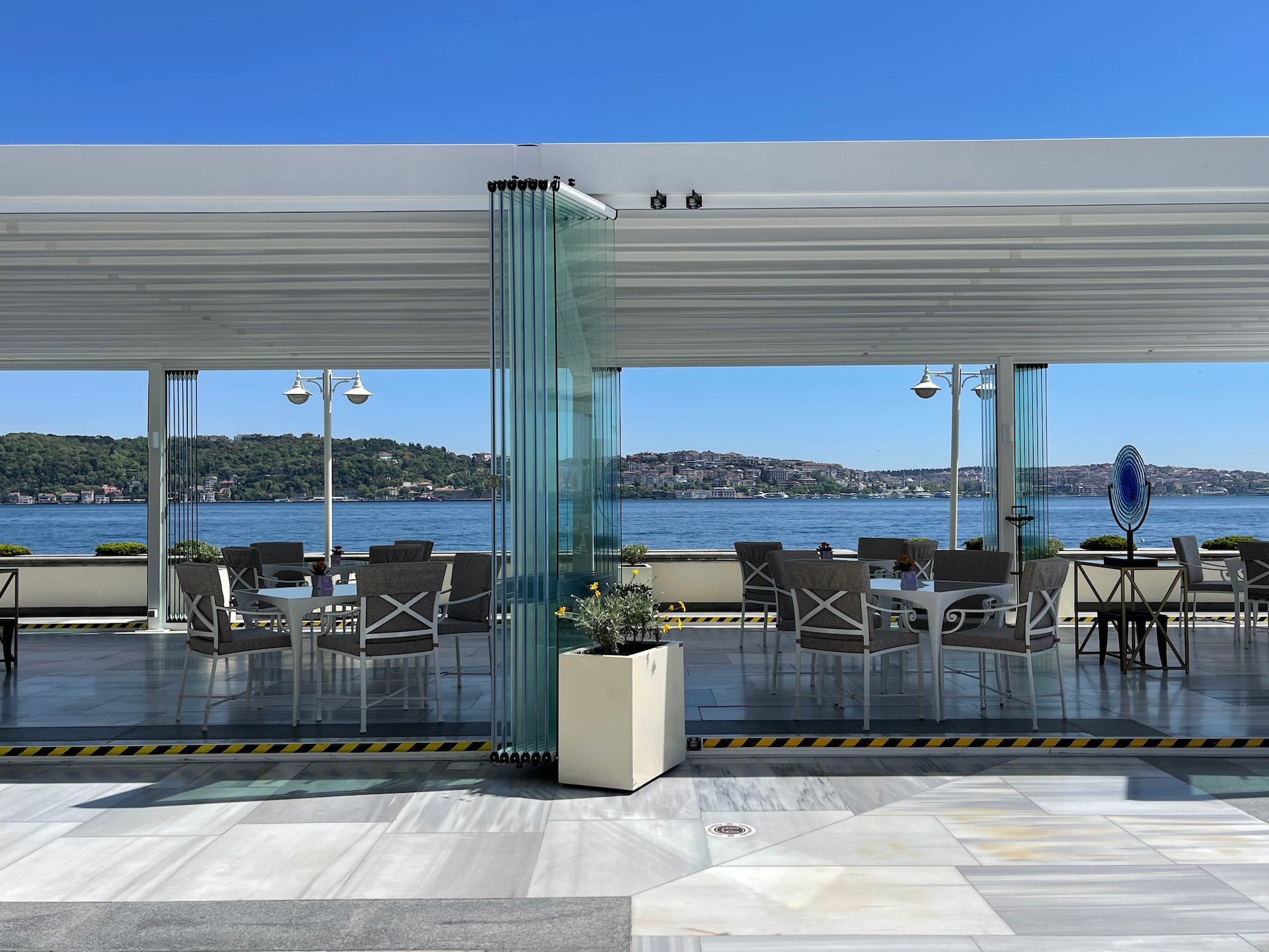 a white covered patio with tables and chairs on a sunny day