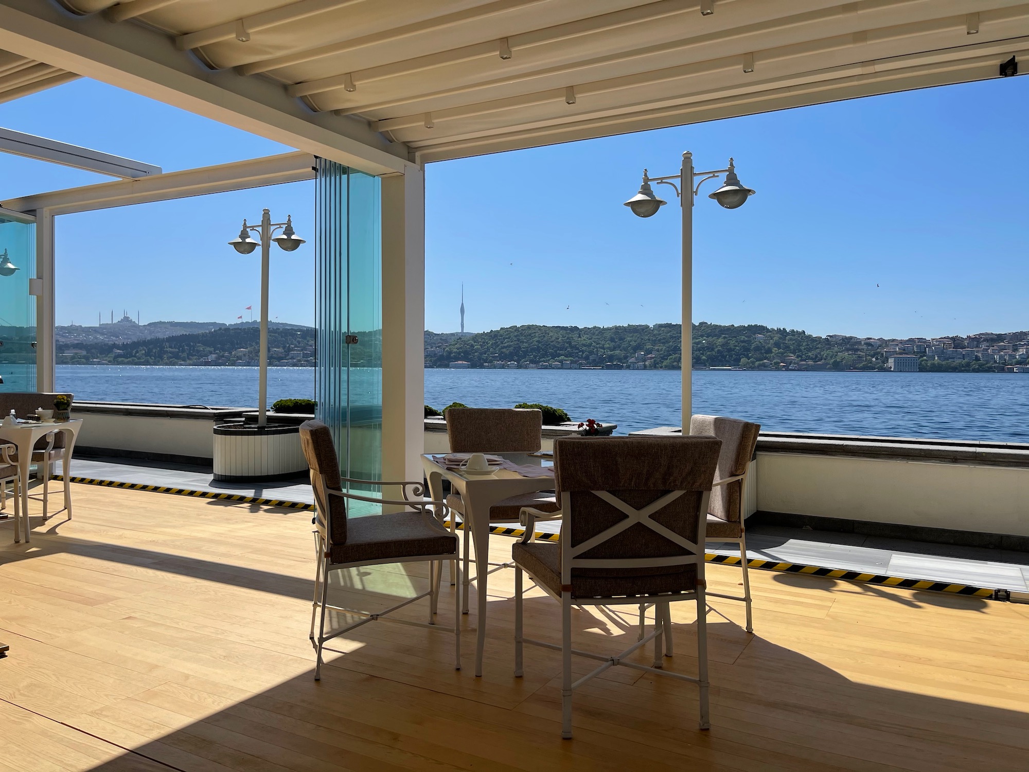 a table and chairs on a deck overlooking a body of water