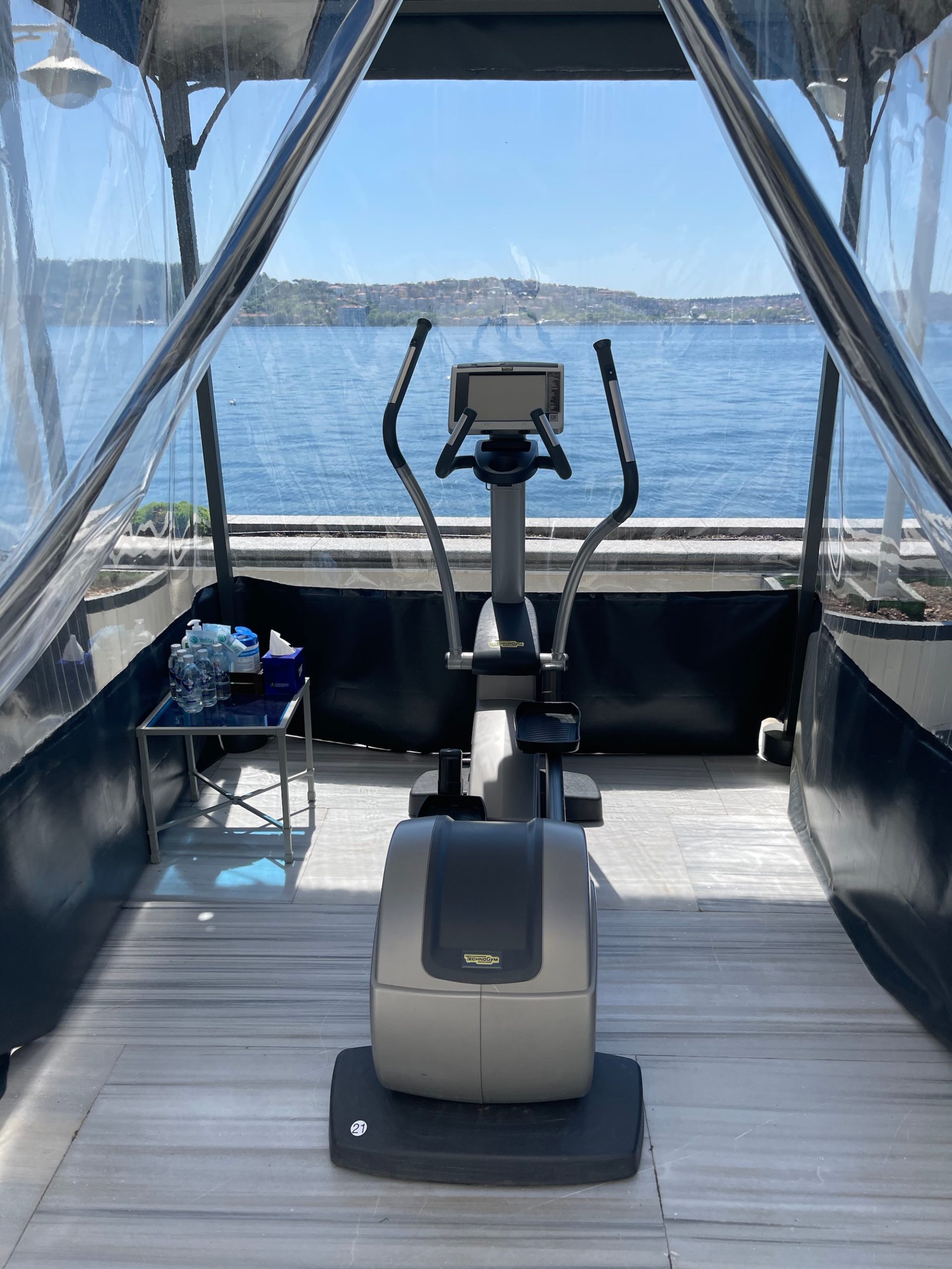 a exercise machine in a room with water in the background