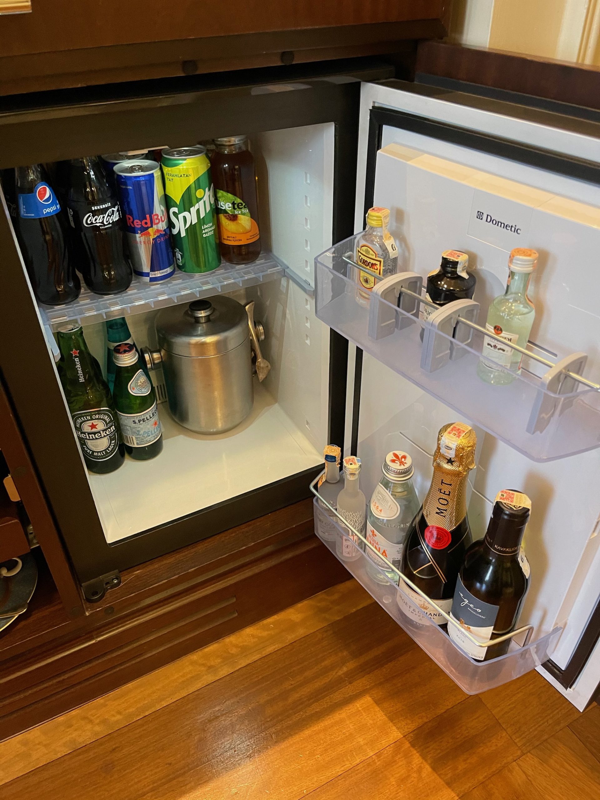 a mini fridge with bottles of beer and cans