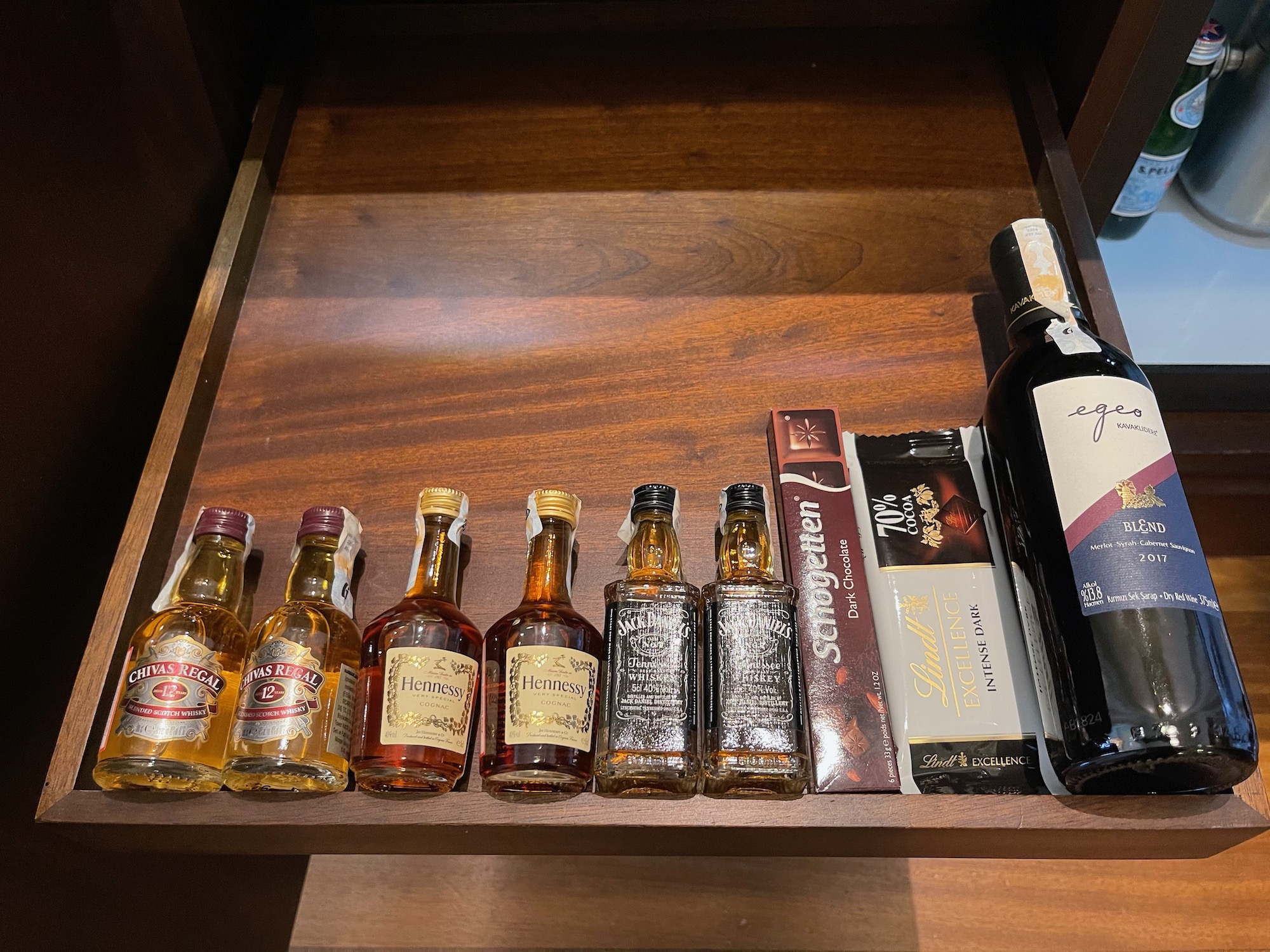 a shelf with liquor bottles and a bottle of chocolate