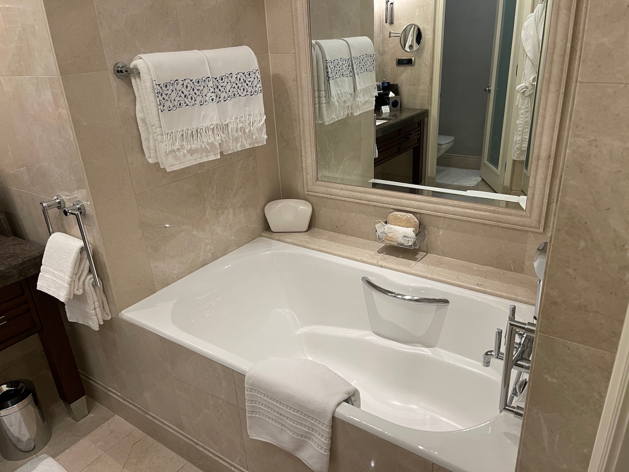a bathtub with a mirror and towels