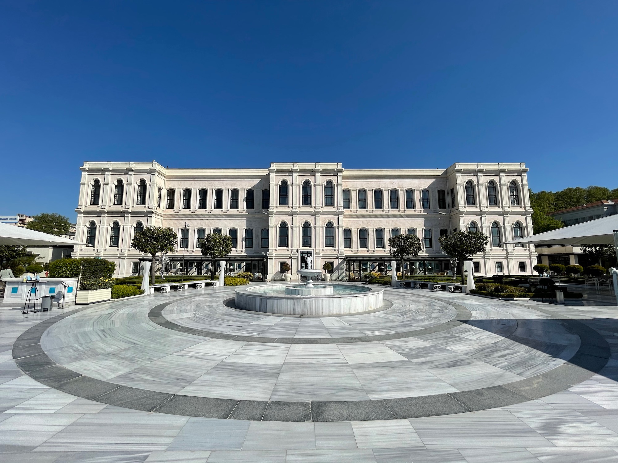 a large white building with a fountain in front of it