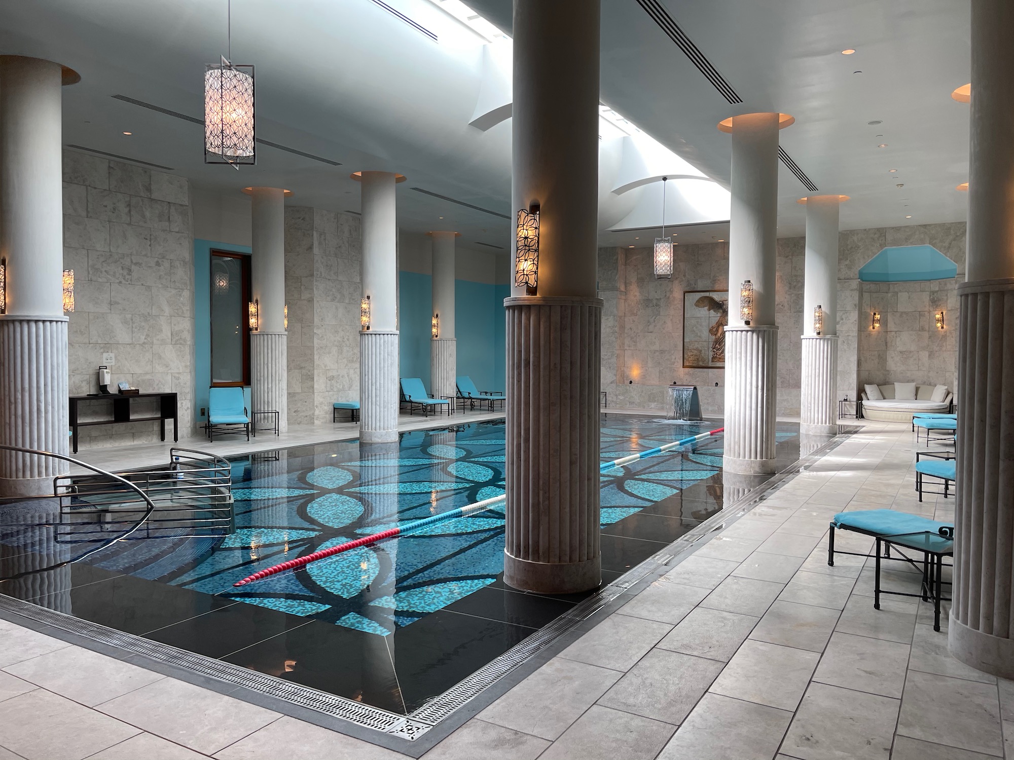 a swimming pool with blue chairs and columns