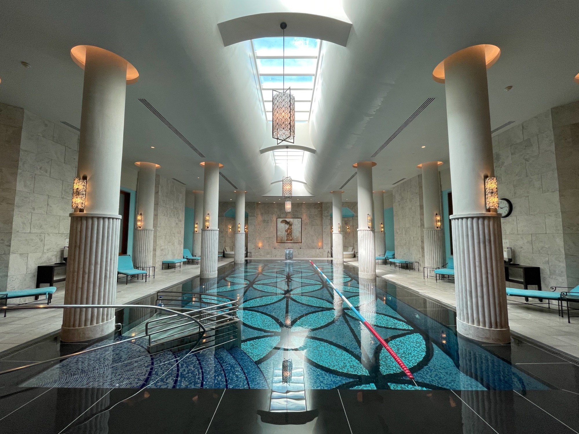 a indoor pool with blue water and columns