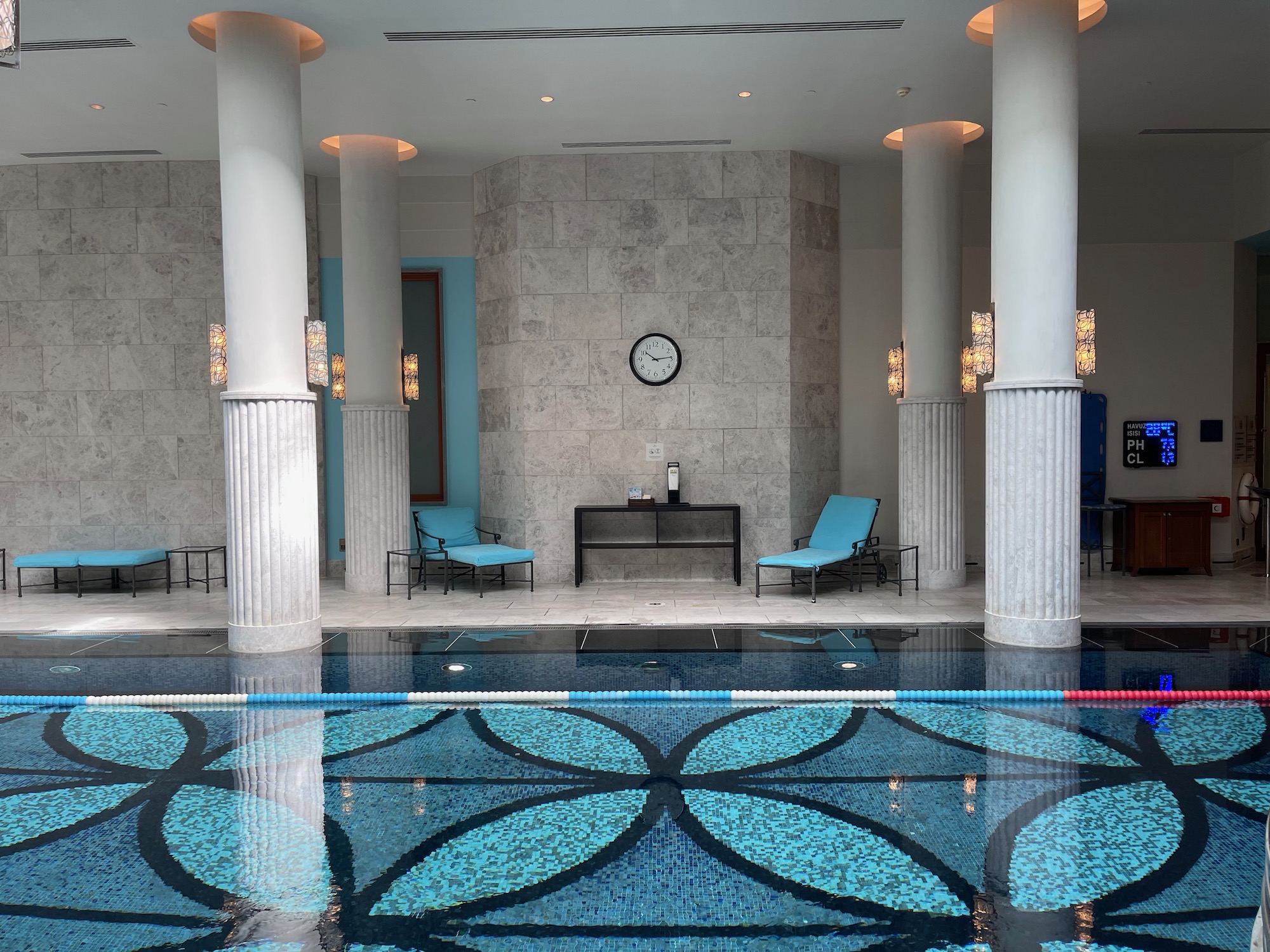 a swimming pool with chairs and a clock