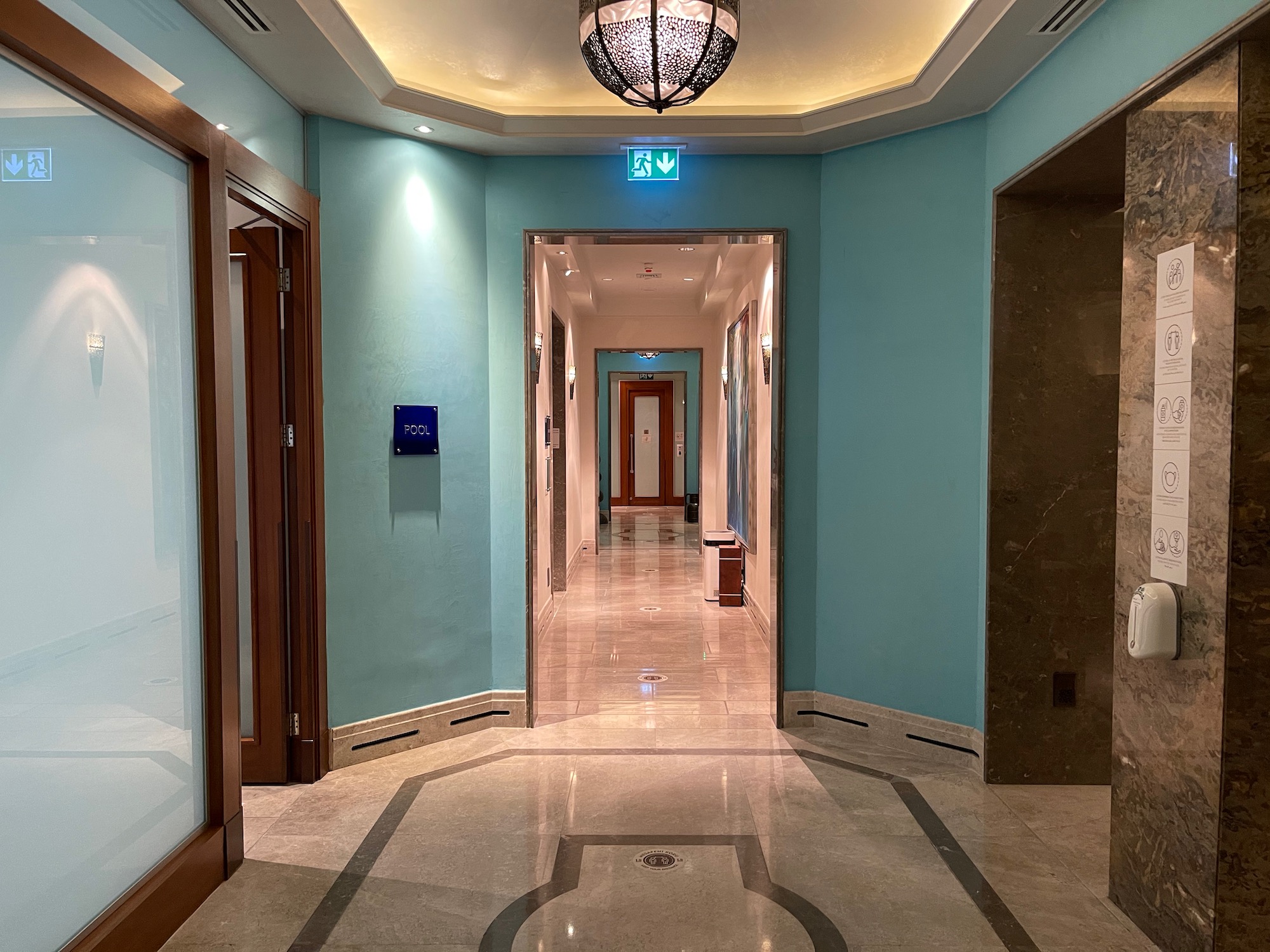 a hallway with a light fixture and a marble floor