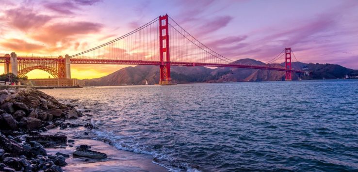 Golden Gate Bridge over water with a sunset