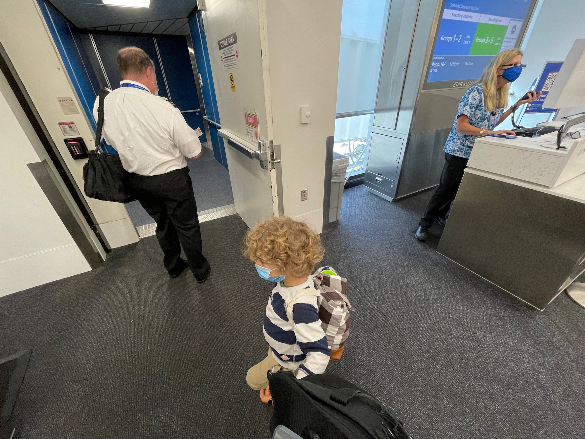 a man and child in a room with a woman and a suitcase