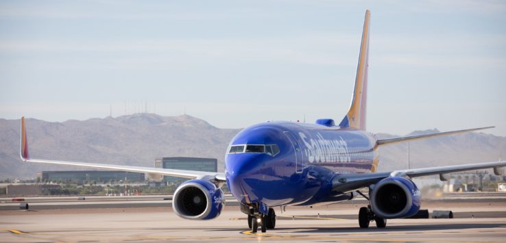 a blue airplane on a runway