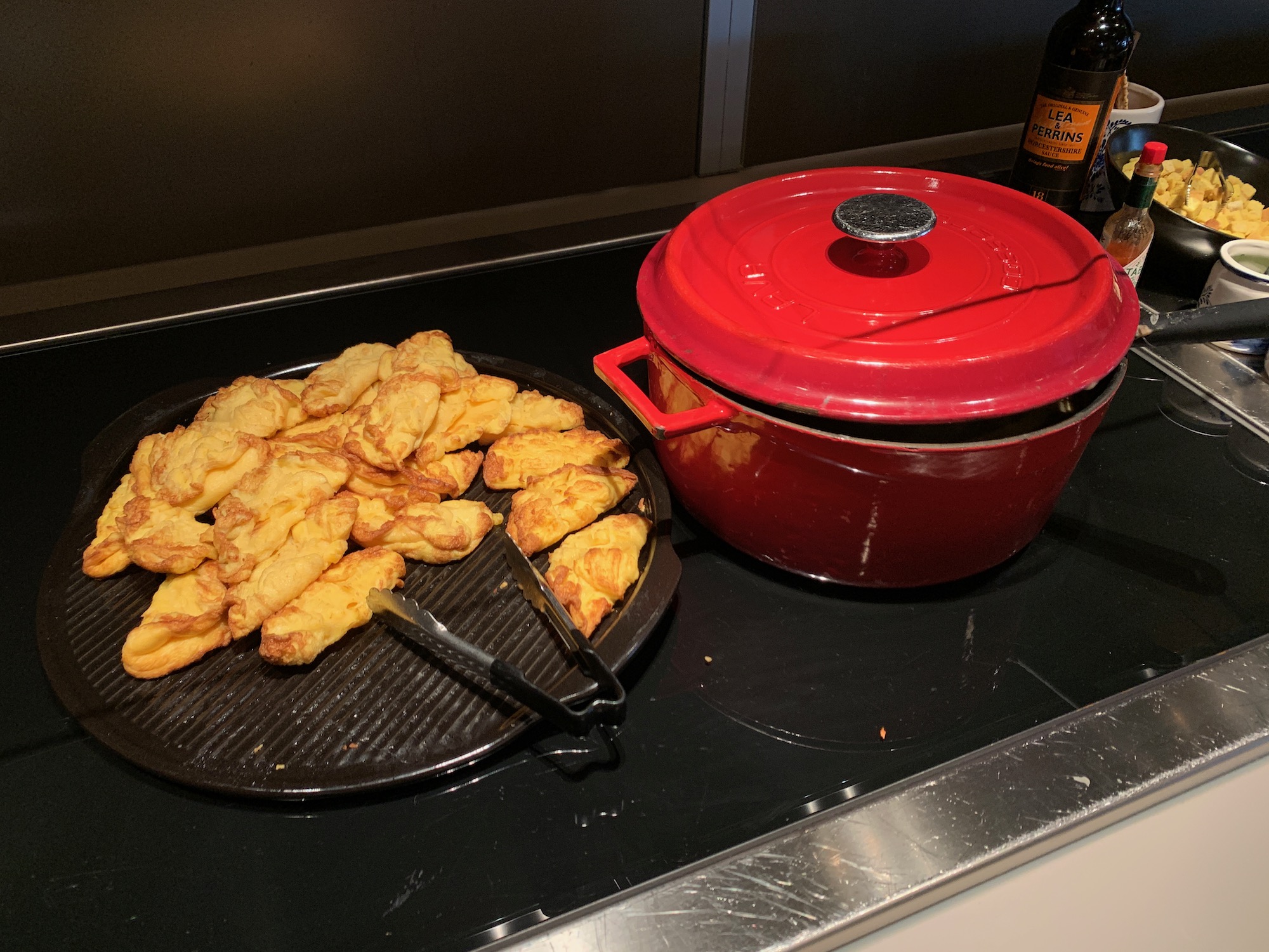 food on a pan next to a red pot