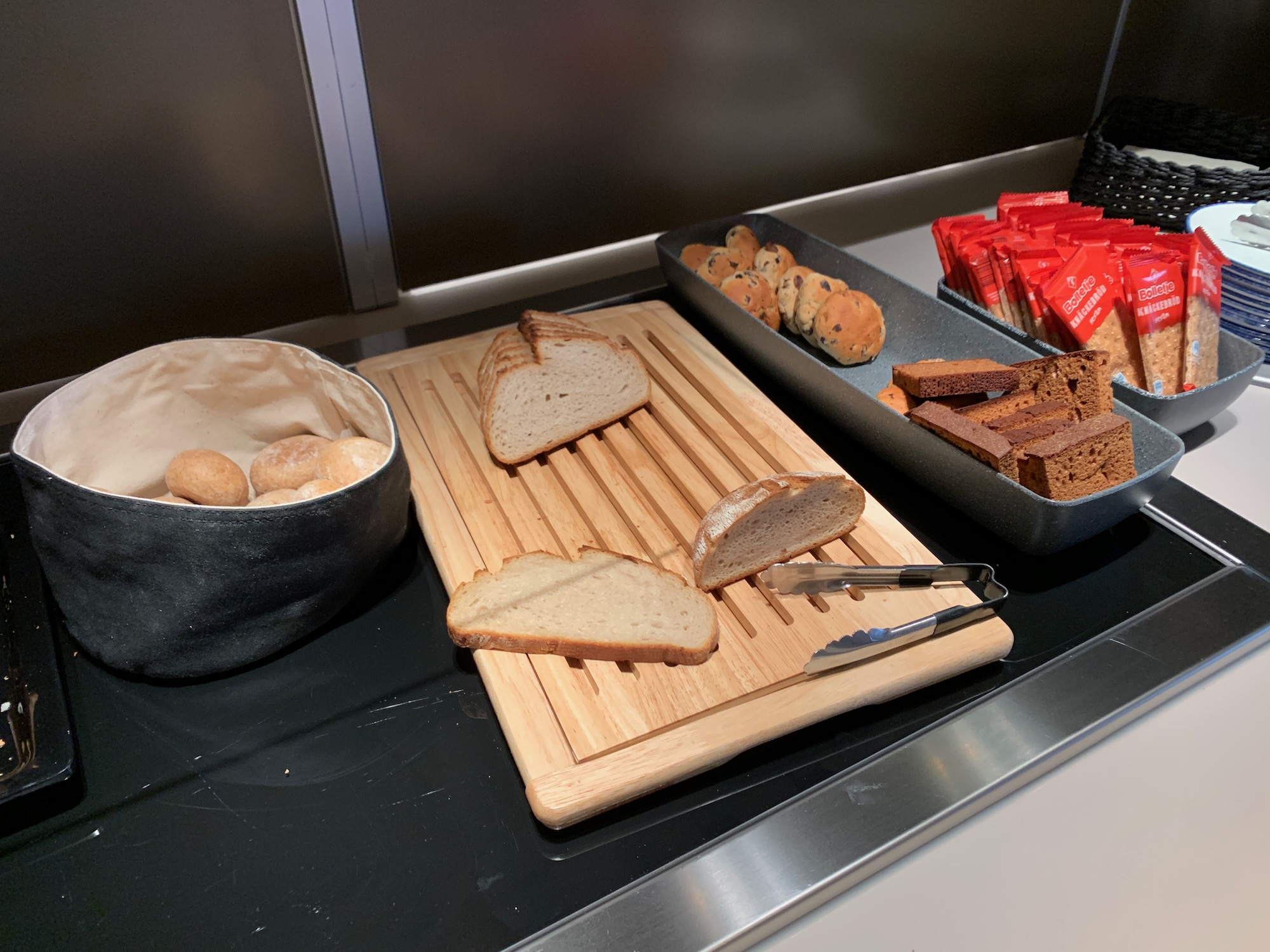 a tray of bread and a bowl of bread on a cutting board