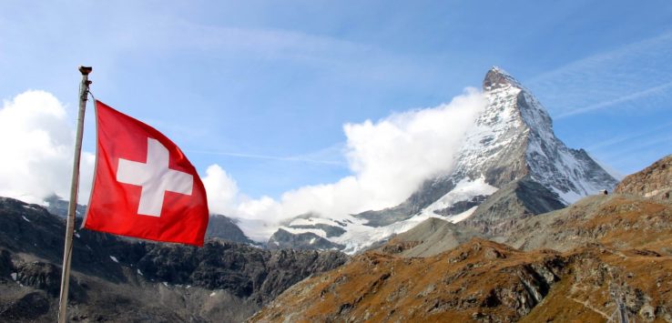 a flag flying in the air with a mountain in the background