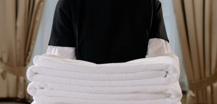 a person holding a stack of towels