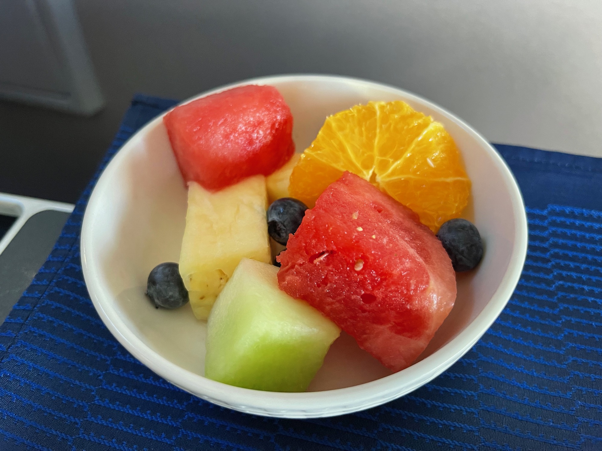 a bowl of fruit on a blue cloth