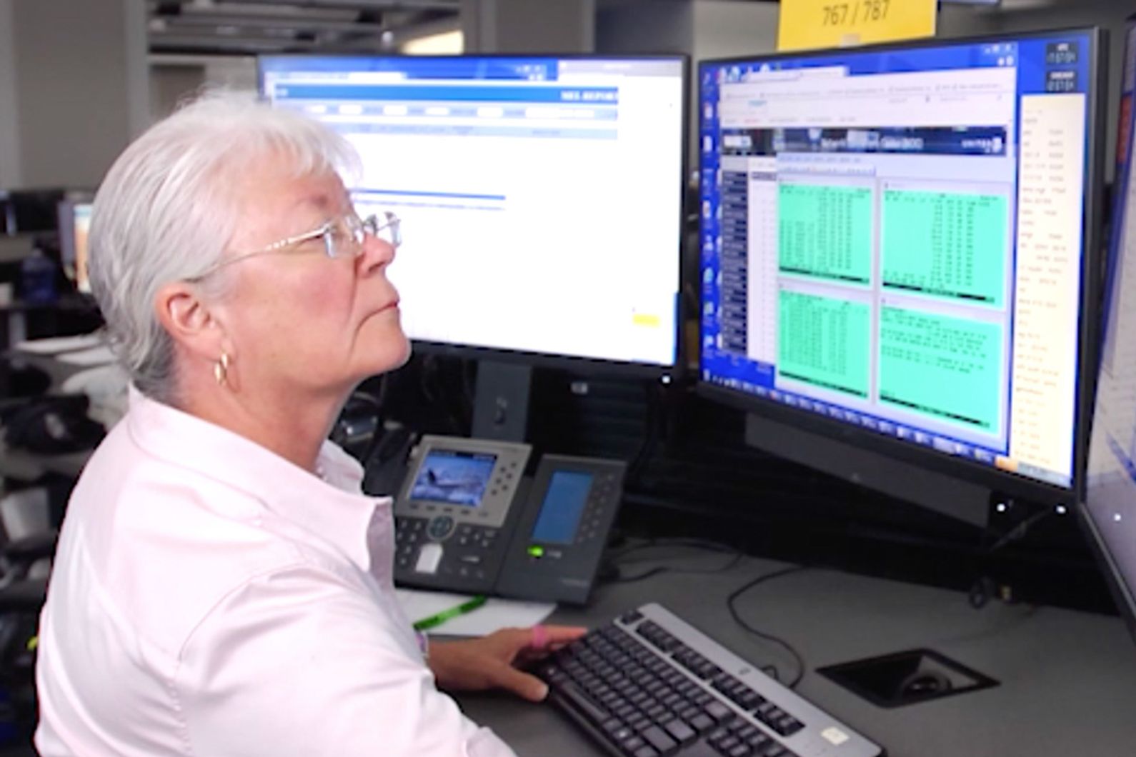 a woman sitting at a desk with a computer