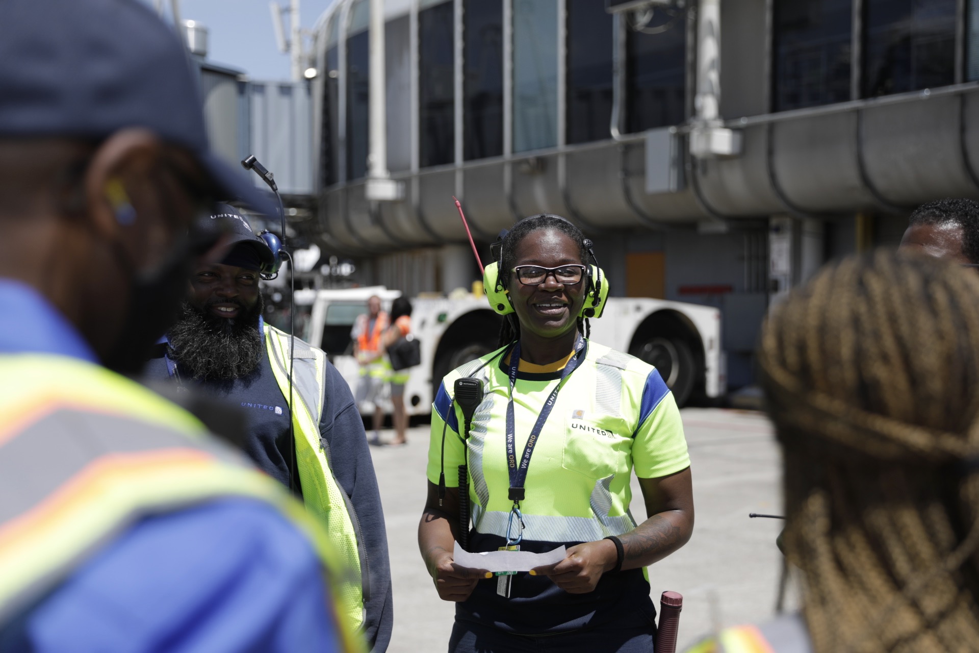 a group of people wearing safety vests and headphones