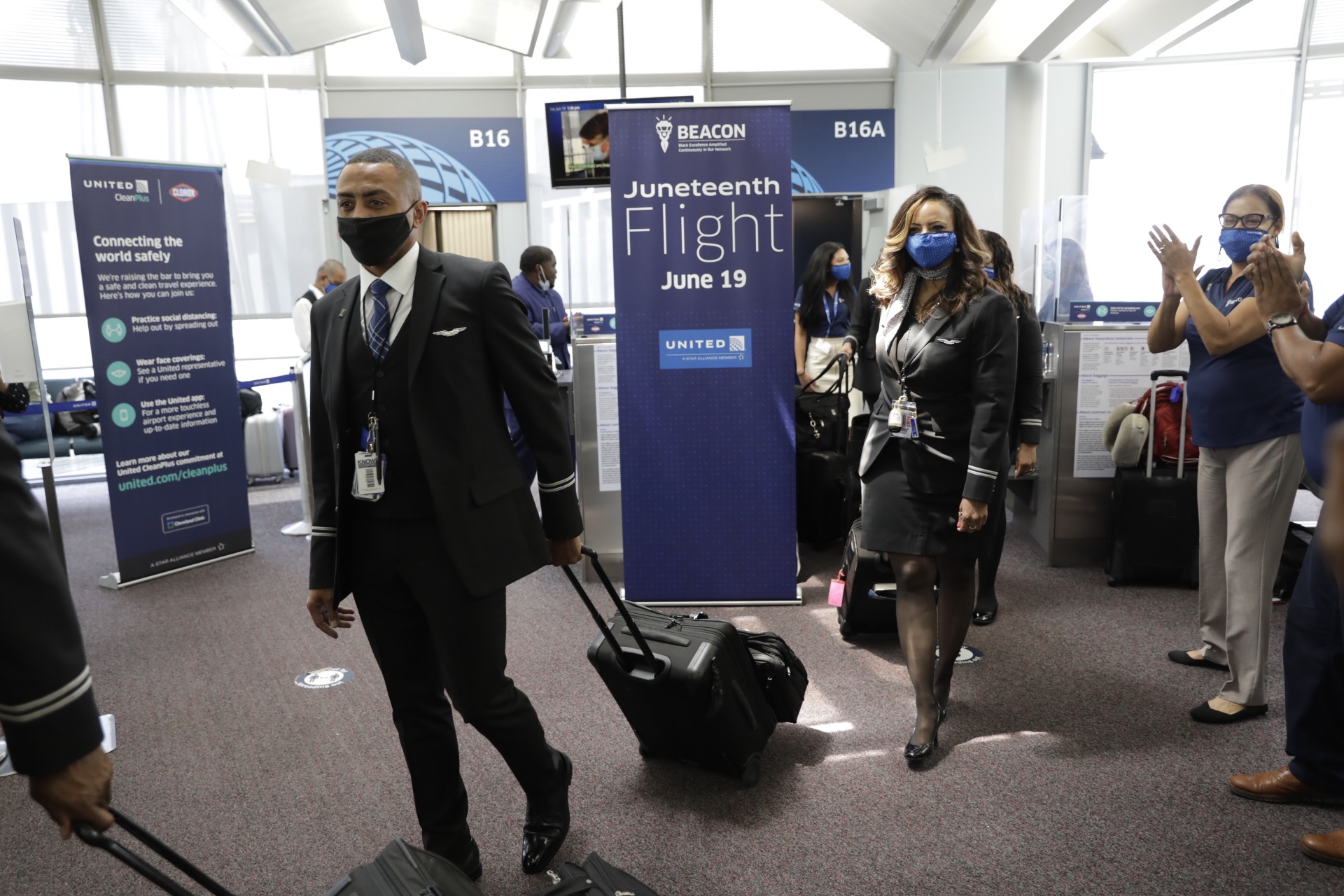 a man and woman wearing face masks walking in an airport